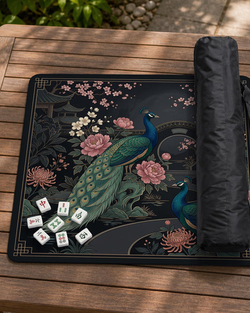 Square black mahjong mat with a gold peacock, blush flowers, dark botanical details, and a gold border.