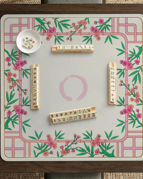 Pink cherry blossom floral mahjong table mat with a cream center and bamboo-style border design.