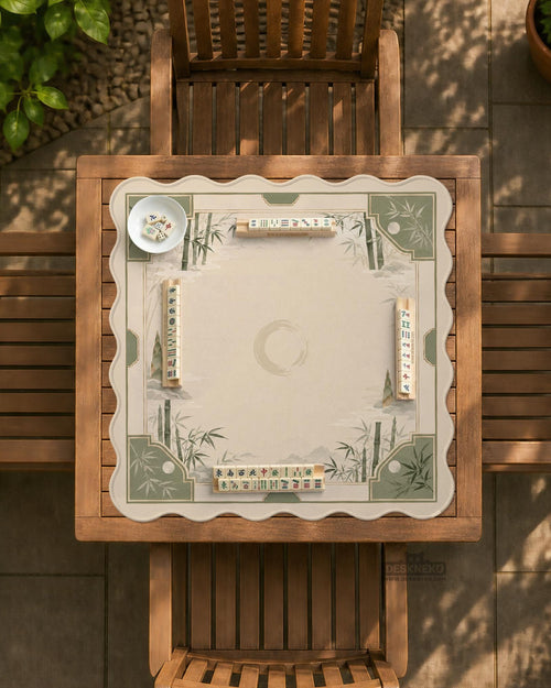 Square mahjong mat with a sage green bamboo and mountain design, cream center, scalloped border details, and gold line accents.