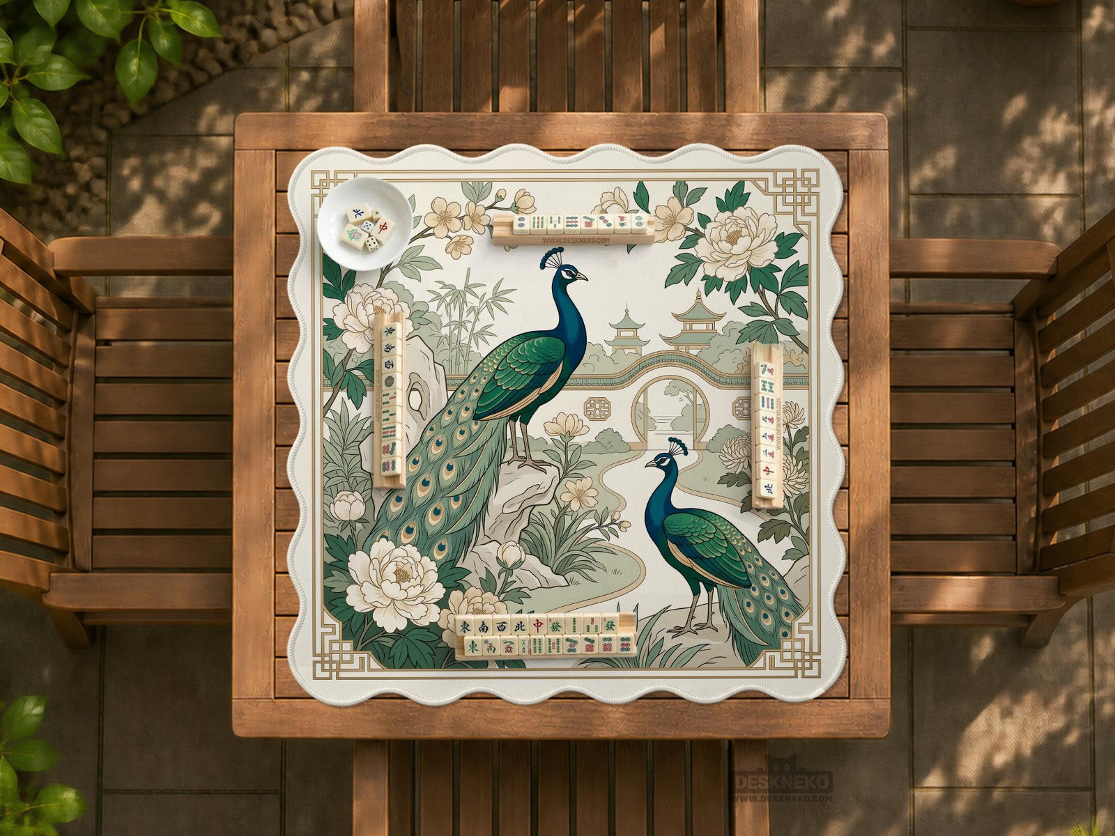 A green mahjong mat with peacock, floral, bamboo, pagoda, and gold border artwork in a scalloped chinoiserie style.