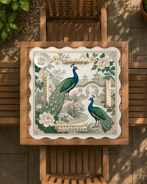 A green mahjong mat with peacock, floral, bamboo, pagoda, and gold border artwork in a scalloped chinoiserie style.