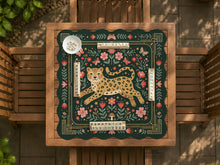 Green mahjong mat with a leopard in the center, floral folk art details, butterflies, leafy accents, and a decorative border.