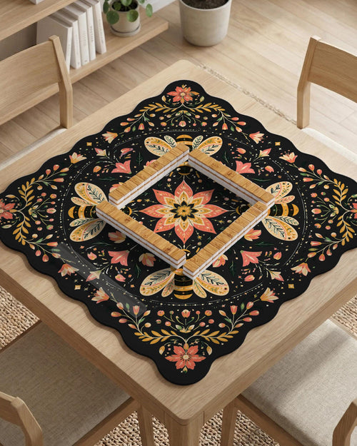 Black mahjong mat with a symmetrical botanical design, coral flowers, golden leaves, and small bees.