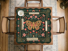 Dark green square mahjong mat with floral border artwork, moth illustrations, and gold line accents.
