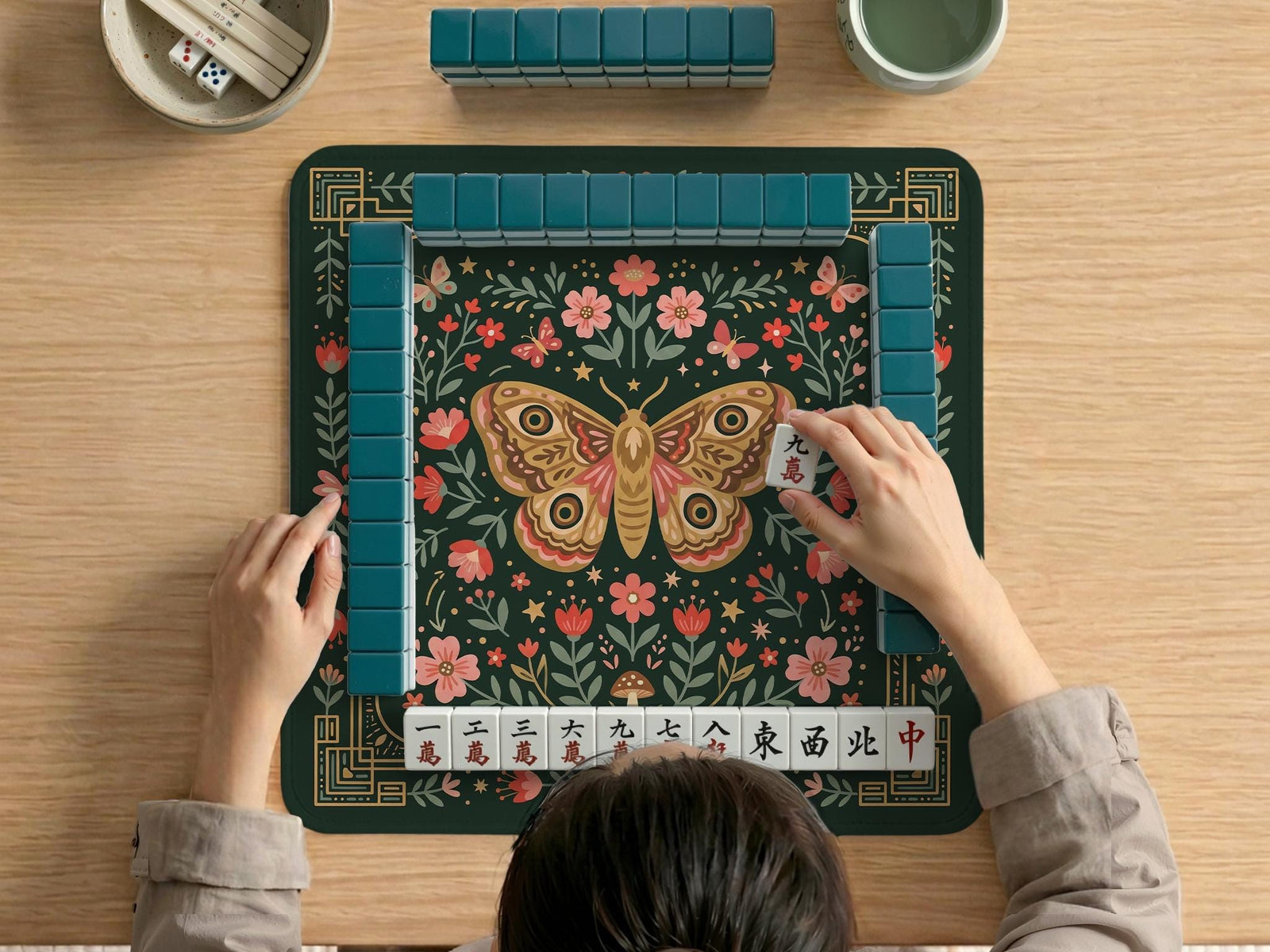 Dark green square mahjong mat with a floral border, moth, butterfly, flower, and mushroom designs in coral, gold, and botanical colors.