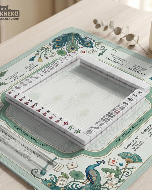 Mint green mahjong mat with peacock feather artwork, framed rule text around the edges, and a clear center play area.