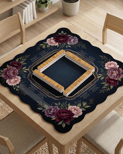 Burgundy mahjong mat with a floral border, gold botanical details, and printed American Mahjong rules on a dark background.