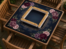 A burgundy floral mahjong mat with a peony border, blush pink and sage leaves, gold accents, and printed rules around an open center.