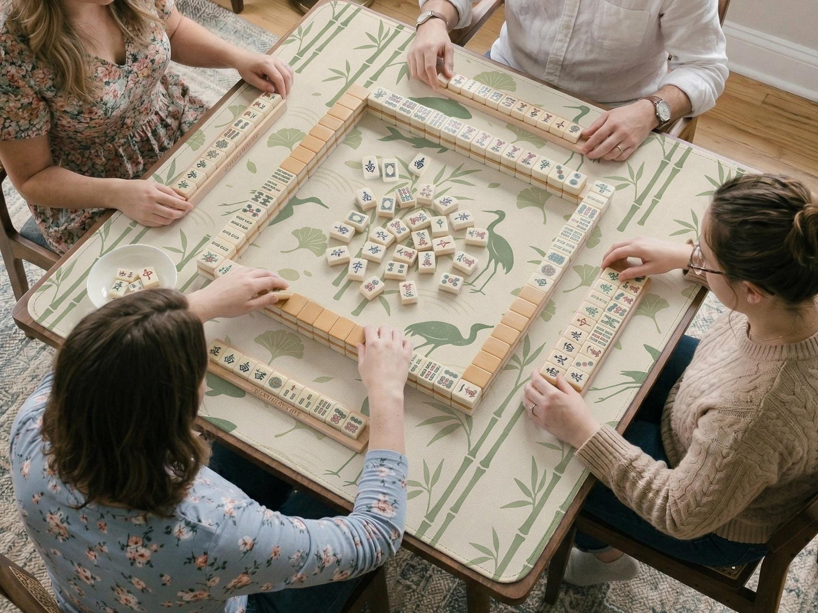 Sage green mahjong mat with a bamboo garden design, koi fish, crane birds, ginkgo leaves, and a cream background.