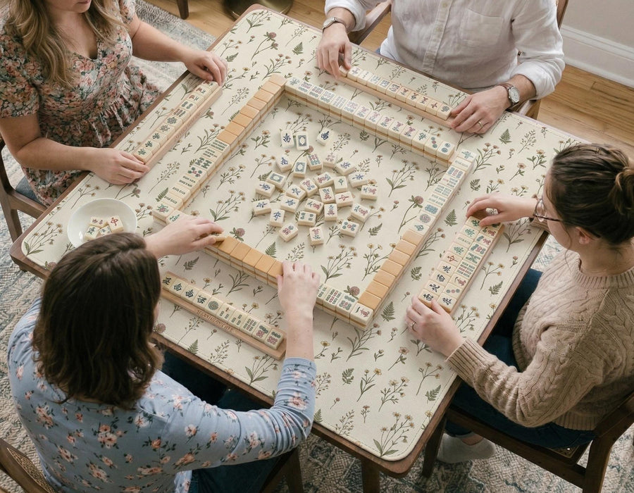 Cream mahjong mat with a delicate meadow flower pattern, soft beige background, and muted sage green leaves.