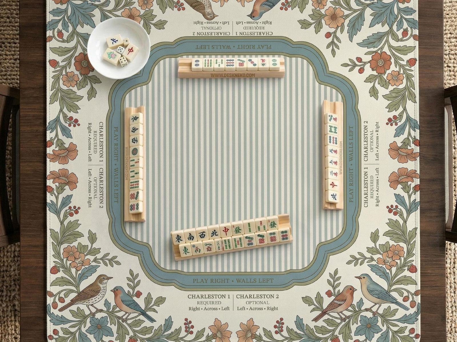 Square mahjong mat with a cream background, blue birds, sage leaves, terracotta flowers, and a decorative botanical border with printed rules text.
