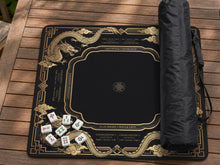 Black square mahjong mat with gold dragon artwork, American rules text, and Charleston guidance printed on the surface.