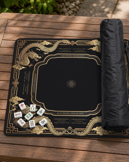 Black square mahjong mat with gold dragon artwork, American rules text, and Charleston guidance printed on the surface.
