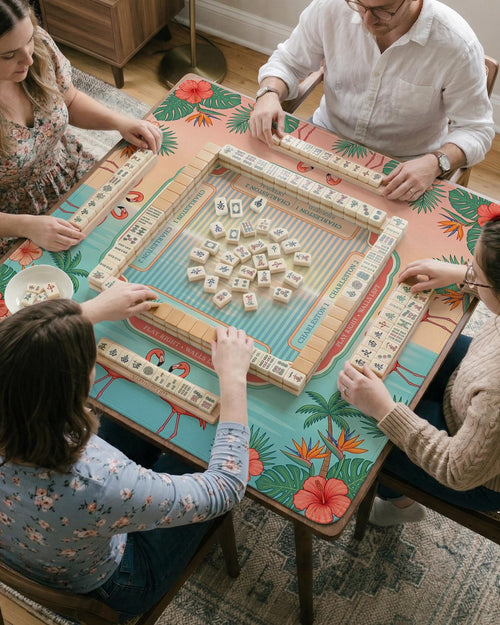 Pink mahjong mat with flamingos, palm leaves, hibiscus flowers, and aqua tropical background.