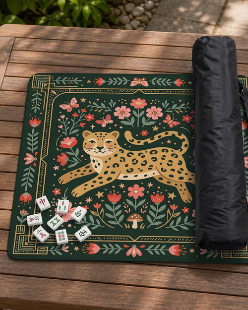 Dark green square mahjong mat with a golden spotted leopard in the center, surrounded by flowers, leafy stems, butterflies, and small star accents.
