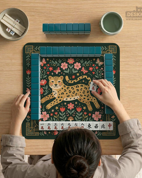 Green square mahjong mat with a leopard in folk art style, surrounded by flowers, butterflies, stars, and mushrooms with a gold border.