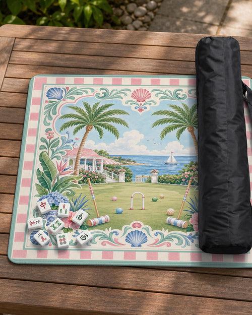 Pastel mahjong mat with a pink gingham border, seashells, hydrangea pots, palm trees, croquet details, and a coastal garden scene.