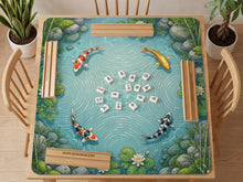 Aqua blue square mahjong mat with koi fish swimming among lotus blooms, green lily pads, and pond water.