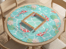 Aqua square mahjong mat with red koi, lotus flowers, lily pads, and tropical leaves on a pond water background with a scalloped edge.