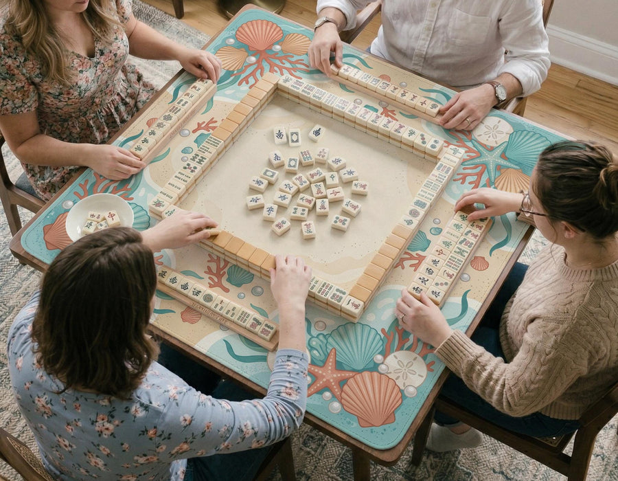 Square mahjong mat with a coral and aqua coastal border featuring shells, coral, pearls, starfish, and waves around a clear center.