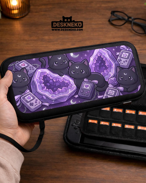Purple carrying case with black cat faces, moon shapes, stars, and crystal geode style artwork for Nintendo Switch.