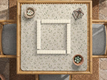Sage green botanical mahjong mat with a cream background, trailing vines, and muted leaf designs.