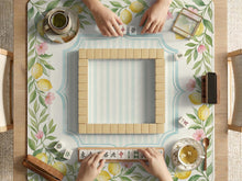 Square pastel yellow mahjong mat with lemon branches, small pink flowers, a striped center, and a light aqua border.