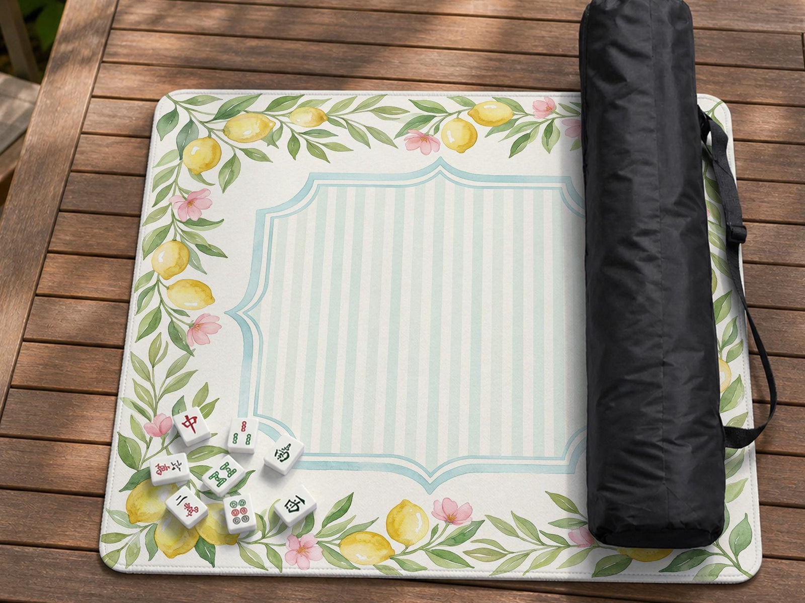 Square yellow mahjong mat with a citrus garden border, green vines, pink blossoms, aqua accents, and a plain center play area.