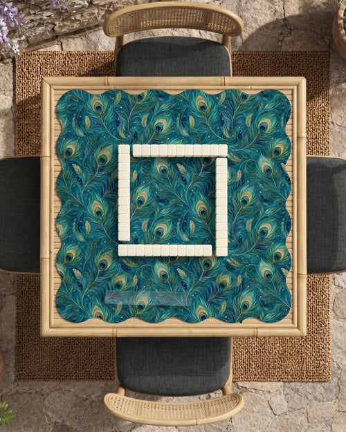 A teal mahjong mat with a peacock feather pattern and scalloped edges.