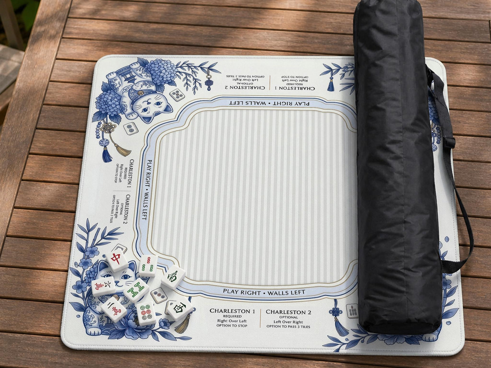 Blue and white mahjong mat with lucky cats, peonies, hydrangeas, small tiles, and gold accents on a decorative tabletop background.