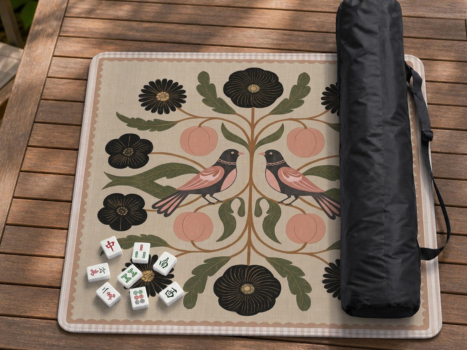 Square mahjong mat with a blush background, vintage flowers, olive leaves, and two mirrored folk-style birds.