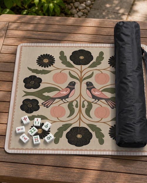Square mahjong mat with a blush background, vintage flowers, olive leaves, and two mirrored folk-style birds.