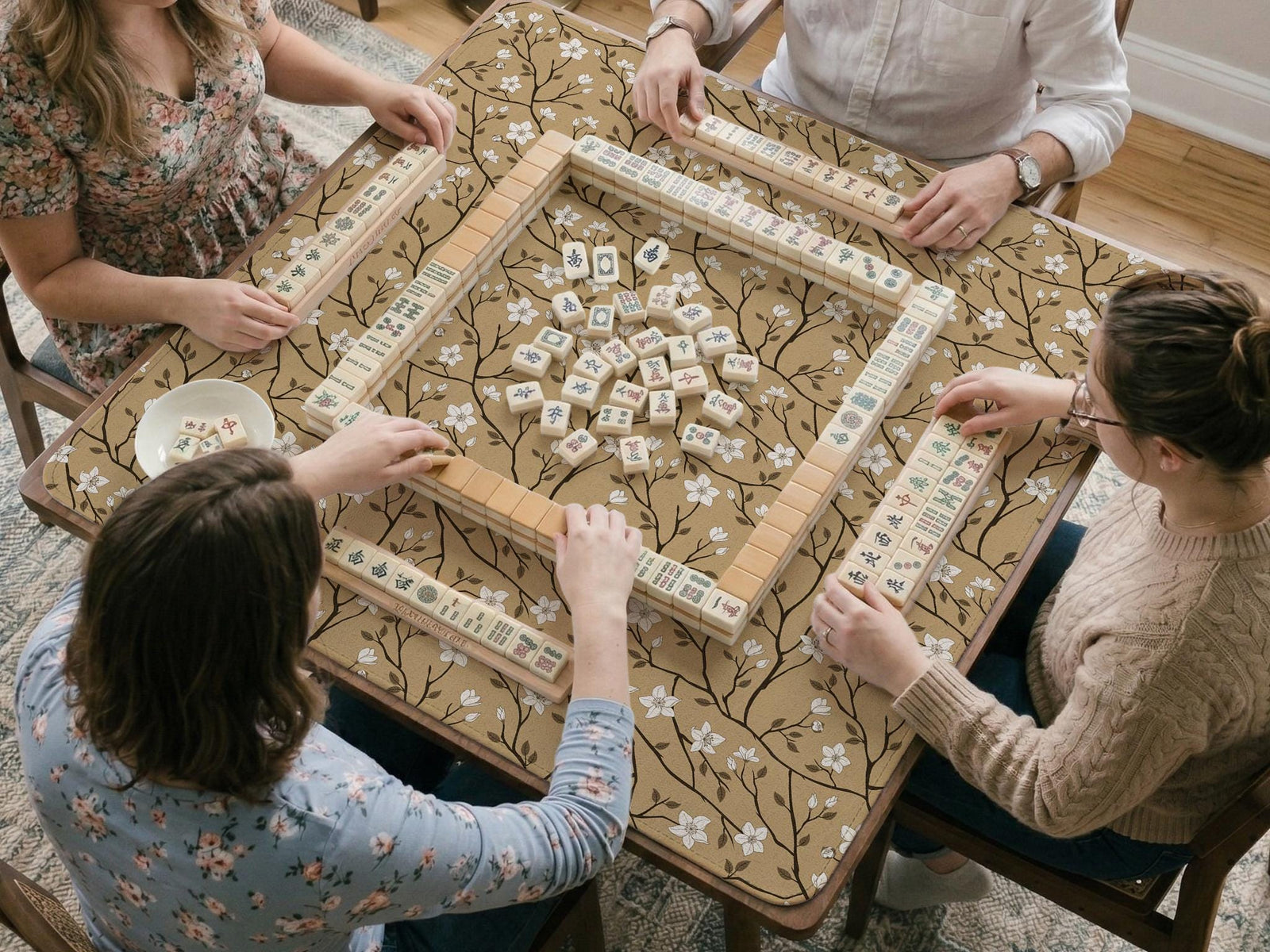 Beige mahjong mat with a white blossom branch floral pattern on a neutral background.