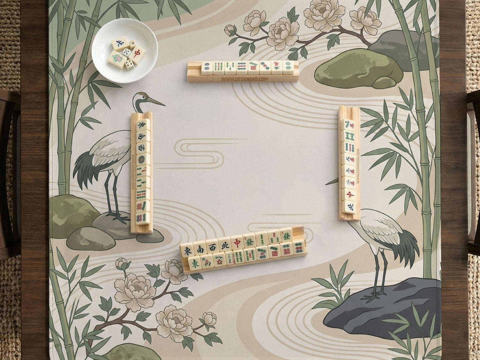 Square mahjong mat with a cream background, sage green cranes, bamboo leaves, peony branches, stones, and thin linework.