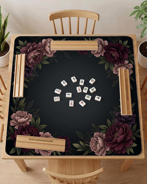 Black square mahjong mat with peony flowers in burgundy and soft pink, muted green leaves, and a blank center area.