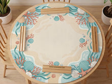 Aqua mahjong mat with seashell and coral artwork, pearl details, and a soft beach color palette in turquoise, cream, and sandy tones.