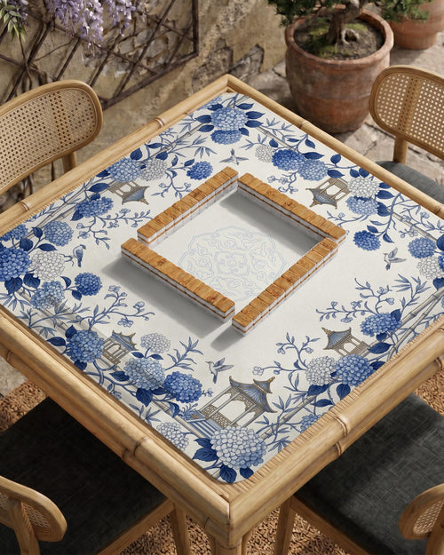 Blue and white square mahjong mat with a hydrangea and bird botanical border and a plain center area.