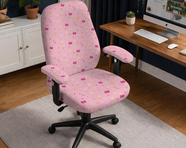 Pink chair cover with a pattern of moons, stars, bows, and small decorative shapes on a chair with armrests.