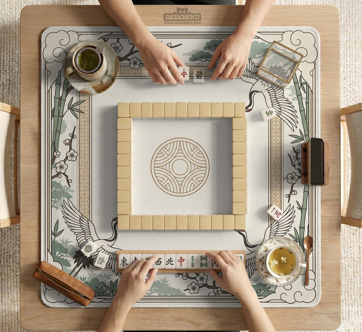 Square mahjong table mat with a cream center and a border design of cranes, bamboo, plum blossoms, and a geometric frame in sage green and warm gold.