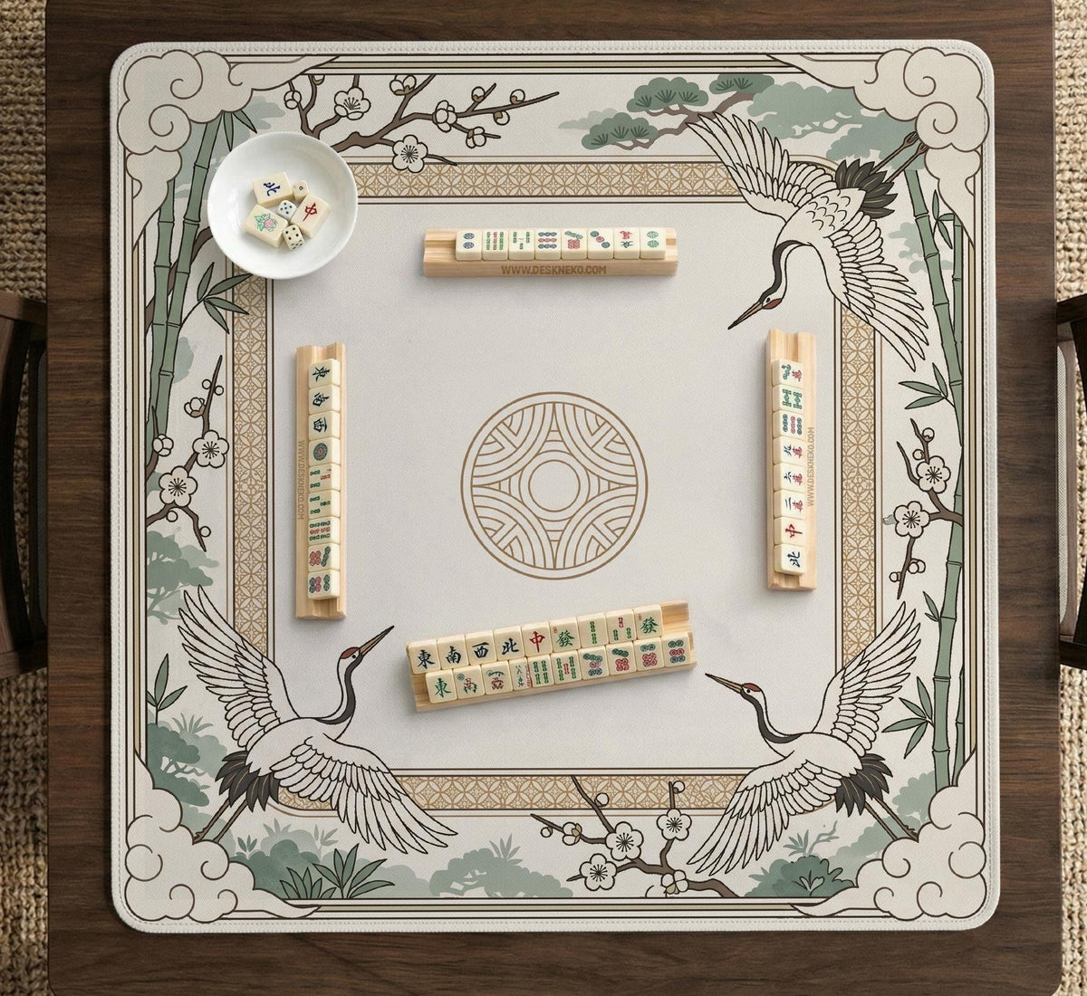 Square mahjong table mat with a cream center and a border design of cranes, bamboo, plum blossoms, and a geometric frame in sage green and warm gold.