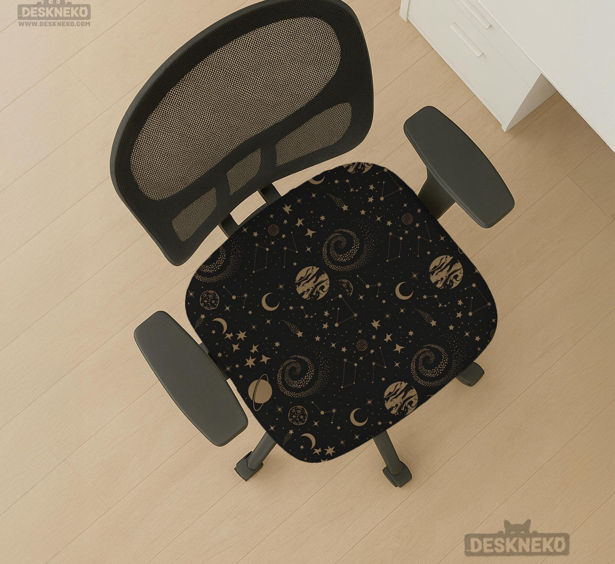 Black chair cover with a dark galaxy pattern, muted gold stars and celestial artwork on a chair.