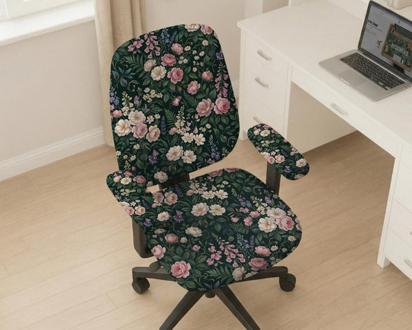 Green chair cover with a dark floral pattern, pink roses, cream flowers, and leafy botanical details on an office chair.
