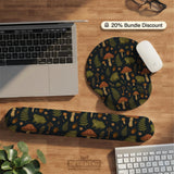 Dark botanical desk mat options with frogs, mushrooms, ferns, and acorns in brown and green tones, plus a matching keyboard wrist rest.