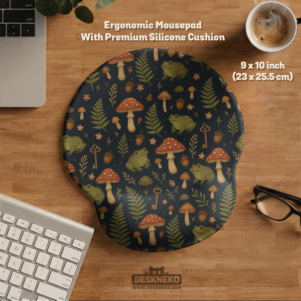 Dark botanical desk mat options with frogs, mushrooms, ferns, and acorns in brown and green tones, plus a matching keyboard wrist rest.
