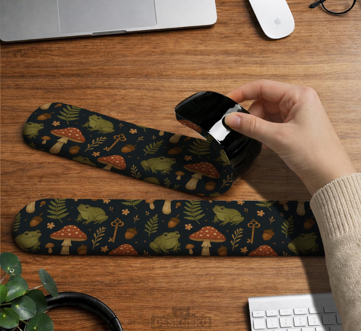 Dark botanical desk mat options with frogs, mushrooms, ferns, and acorns in brown and green tones, plus a matching keyboard wrist rest.