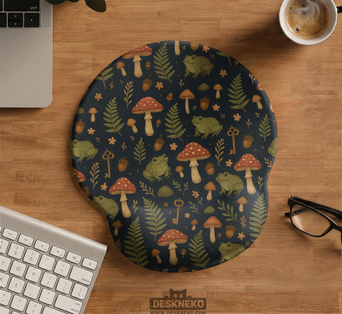 Dark botanical desk mat options with frogs, mushrooms, ferns, and acorns in brown and green tones, plus a matching keyboard wrist rest.