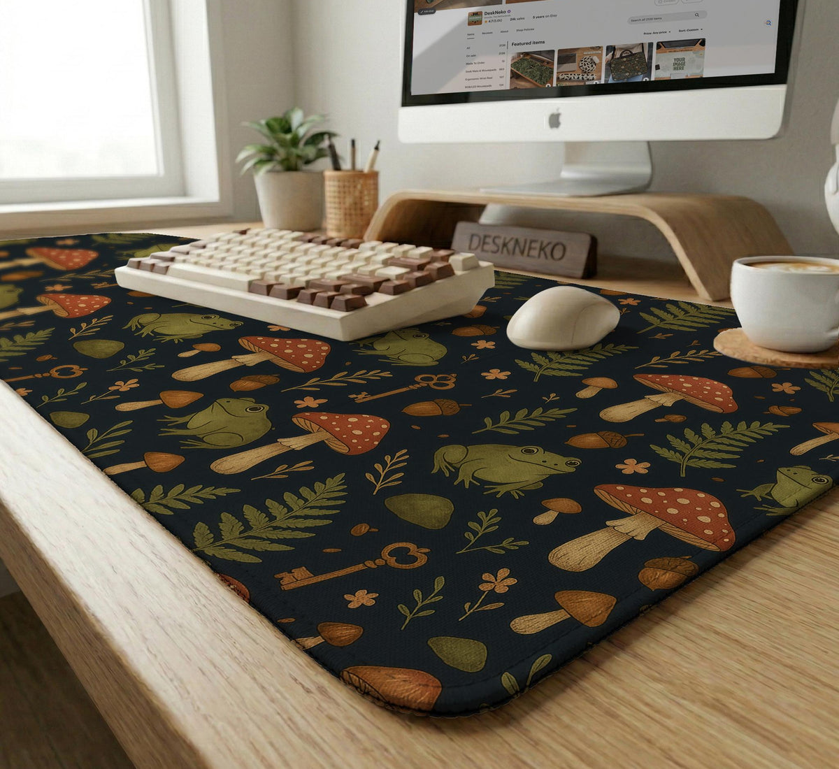 Dark forest-themed desk mat with an all-over pattern of frogs, mushrooms, fern leaves, acorns, tiny flowers, and antique keys.
