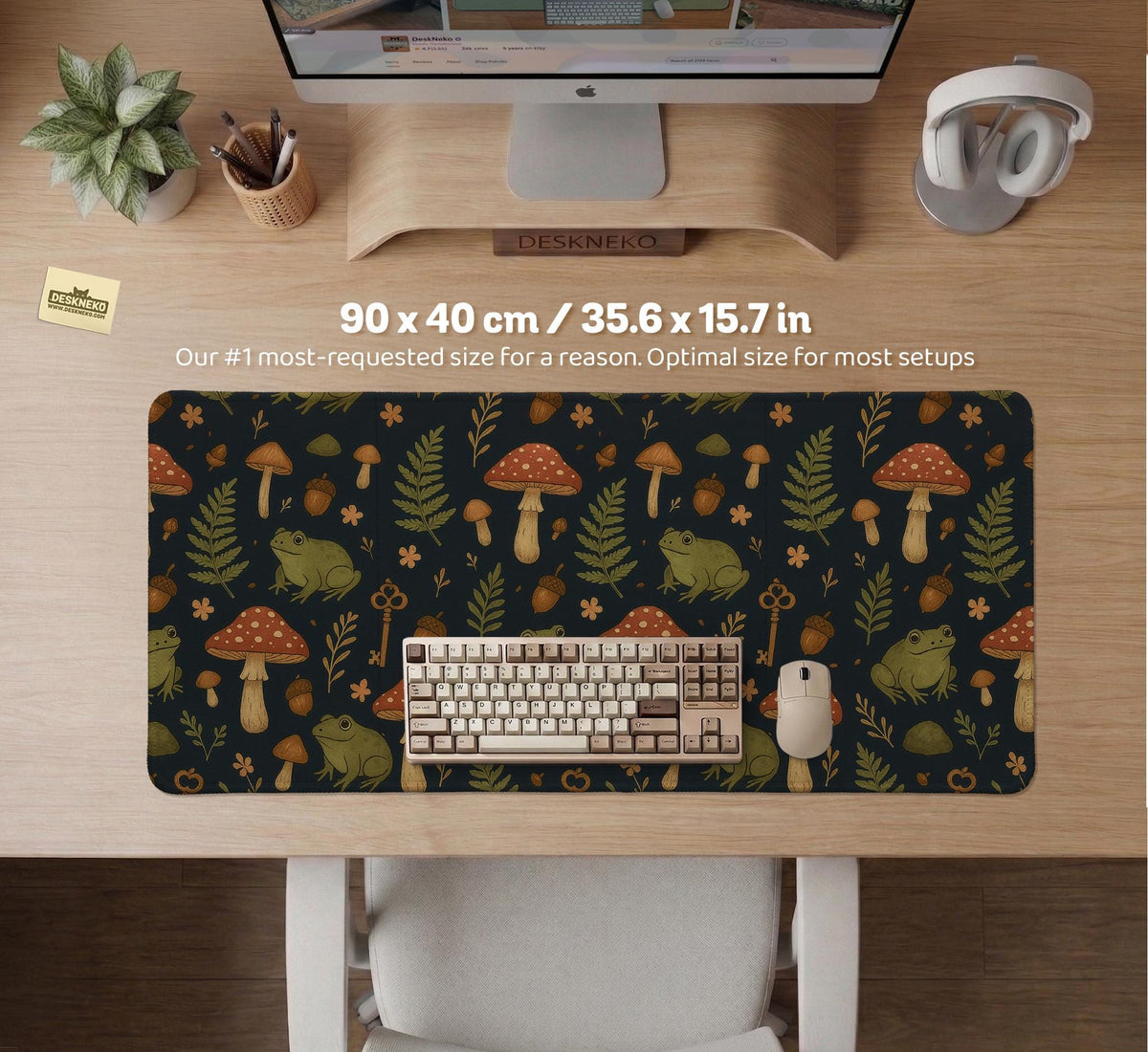 Dark forest-themed desk mat with an all-over pattern of frogs, mushrooms, fern leaves, acorns, tiny flowers, and antique keys.