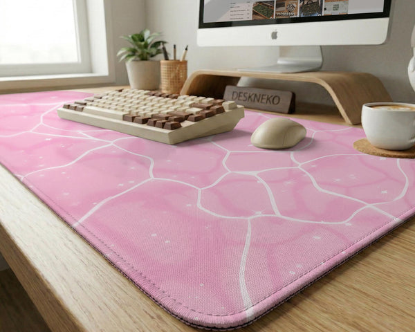 Pastel pink desk mat with a marble-style design, white flowing lines, and small sparkle accents.