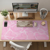 Pastel pink desk mat with a marble-style design, white flowing lines, and small sparkle accents.